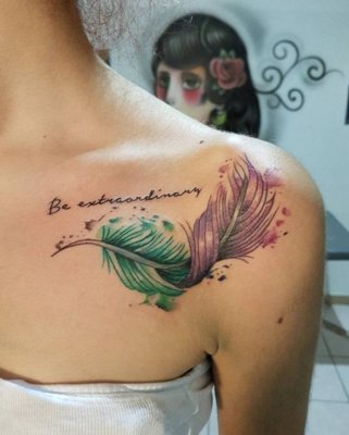 Tatouage plume vert et rose avec des écritures sur le devant de l'épaule